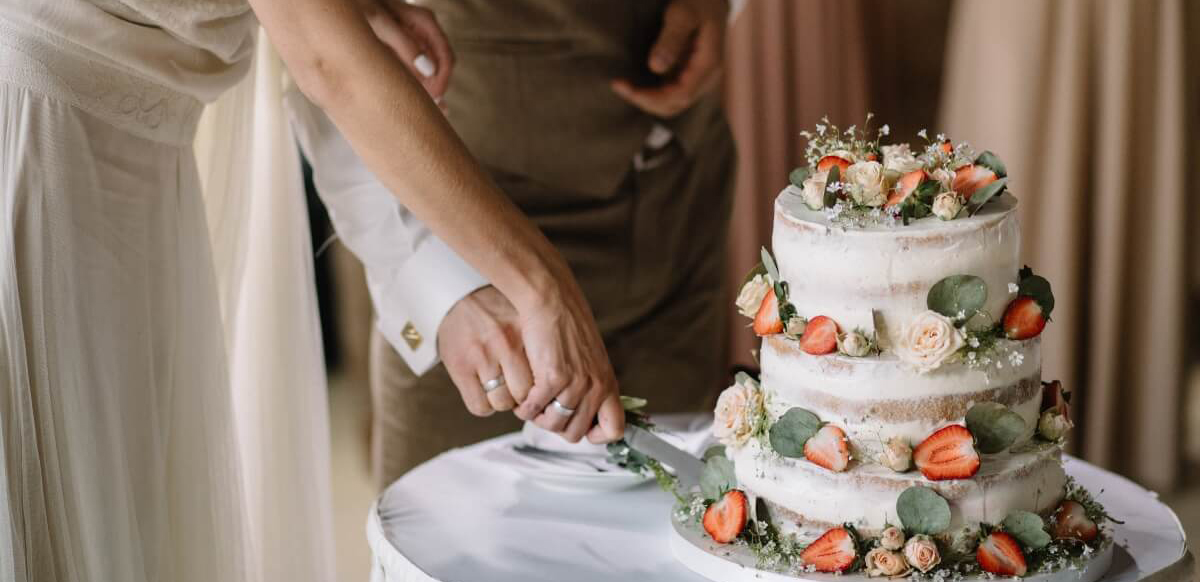 Novomanželé krájející svatební dort